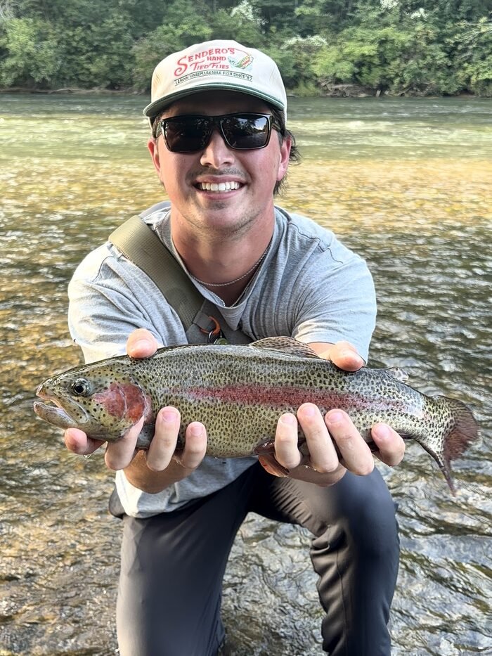 Ben kneeling in the Chattahoochee holding a large rainbow trout